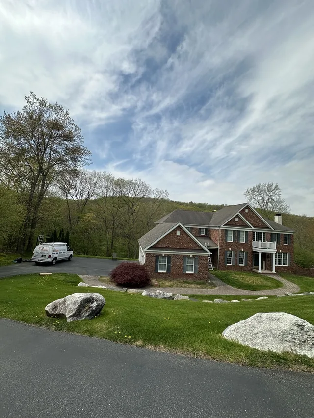 Roofer photographing damage during a free roof repair inspection in NJ
