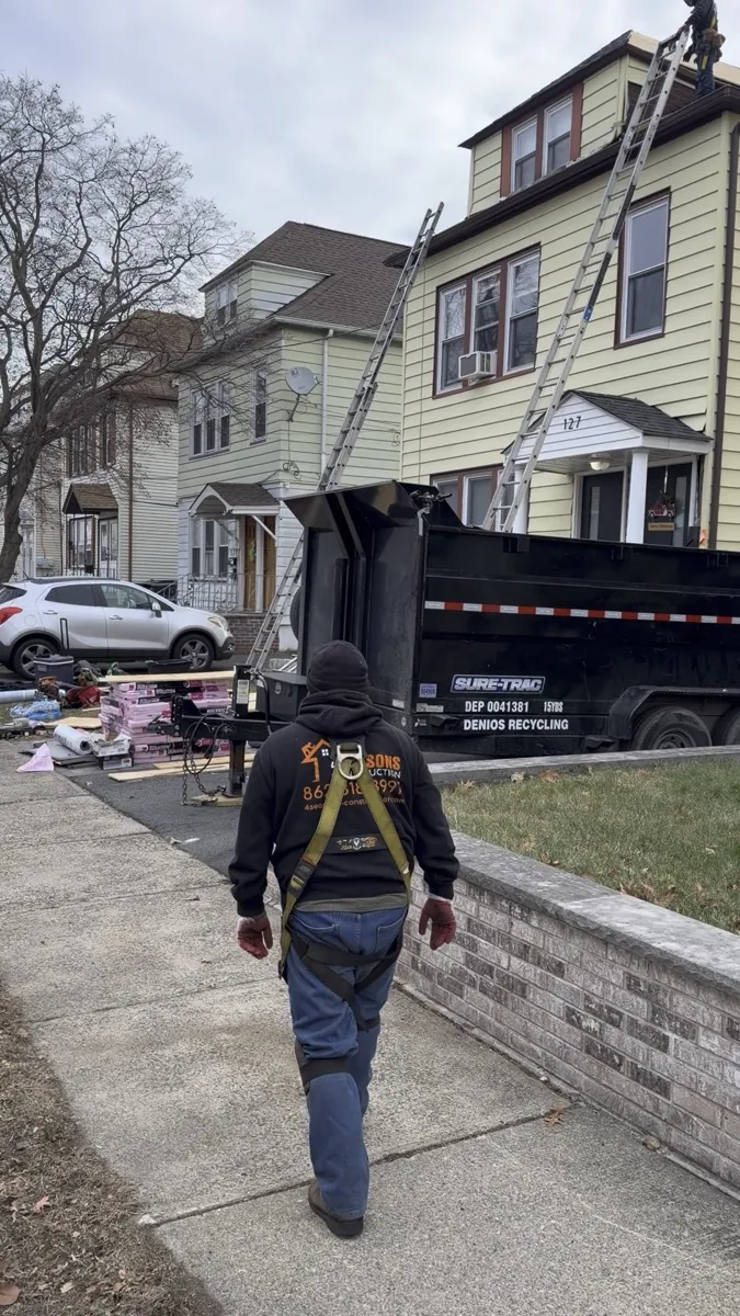 Four Seasons crew loading tear-off debris into a dumpster on a North Jersey job
